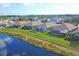 Aerial view of lakeside homes featuring screened lanais and well-manicured lawns along a scenic blue lake at 1771 Scarlett Ave, North Port, FL 34289