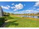 Landscaped backyard with scenic lake views on a sunny day at 1771 Scarlett Ave, North Port, FL 34289