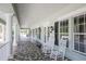 Inviting clubhouse porch featuring white rocking chairs, a tiled floor, and columns, perfect for relaxing at 1771 Scarlett Ave, North Port, FL 34289