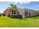 Lawn view of the home's screened-in patio and well-maintained backyard landscaping at 1771 Scarlett Ave, North Port, FL 34289