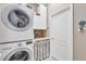 Efficient laundry room with a stacked washer and dryer, storage cabinets, and a practical design at 1771 Scarlett Ave, North Port, FL 34289