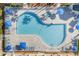 Aerial view of a beautiful community pool with blue umbrellas and lounge chairs at 1771 Scarlett Ave, North Port, FL 34289