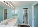 Bright bathroom featuring double sinks, walk-in shower with glass door, and a large mirror at 1800 Birmingham Blvd, Punta Gorda, FL 33980