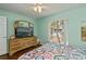 Bedroom featuring hardwood floors, dresser with TV, and a bright window at 1800 Birmingham Blvd, Punta Gorda, FL 33980