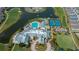 Aerial view of a large community clubhouse with a pool, tennis courts, and meticulously maintained landscaping at 1800 Birmingham Blvd, Punta Gorda, FL 33980