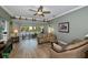 A comfy living room featuring tile floors, crown molding, neutral walls, a ceiling fan, and sliding glass doors at 1800 Birmingham Blvd, Punta Gorda, FL 33980