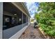 Covered outdoor patio with a pathway to a grill area and lush landscaping at 1800 Birmingham Blvd, Punta Gorda, FL 33980