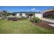 Charming single-story home featuring solar panels, a well-manicured lawn, and a cute black fence at 18702 Van Nuys Cir, Port Charlotte, FL 33948