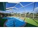 Backyard screened-in pool area with artificial turf surrounding the pool at 18702 Van Nuys Cir, Port Charlotte, FL 33948