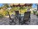 Outdoor backyard patio area featuring a glass table, seating, and an umbrella at 188 Cypress Nw Ave, Port Charlotte, FL 33952