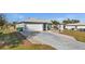 Home featuring an attached two-car garage and a long concrete driveway at 188 Cypress Nw Ave, Port Charlotte, FL 33952