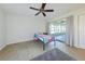 Bedroom with tile floor and ceiling fan overlooking an enclosed porch at 21192 Knollwood Ave, Port Charlotte, FL 33952