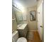 A well-lit bathroom with gray vanity, artwork, and decorative mirror at 22441 Westchester Blvd # 1100D, Port Charlotte, FL 33980