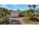 Lovely one-story home featuring a two-car garage, tile roof, and lush tropical landscaping at 2284 Palm Tree Dr, Punta Gorda, FL 33950