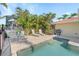 Relaxing poolside patio with seating, lounge chairs, and lush tropical landscaping at 2284 Palm Tree Dr, Punta Gorda, FL 33950