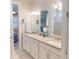 Ensuite bathroom features a double vanity with a large framed mirror and a glass-enclosed shower at 2478 Brassica Dr, North Port, FL 34289