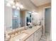 Bathroom featuring double sinks, neutral countertops, and a view of the walk-in closet at 2478 Brassica Dr, North Port, FL 34289