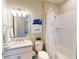 Well-lit bathroom with a white vanity, framed mirror, and a shower-tub combo with a decorative curtain at 2478 Brassica Dr, North Port, FL 34289