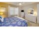 Cozy bedroom with a white dresser, ceiling fan and blue and white patterned bedding at 2478 Brassica Dr, North Port, FL 34289