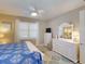 Bedroom featuring a ceiling fan, white dresser, and blue and white patterned bedding at 2478 Brassica Dr, North Port, FL 34289