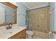 Bathroom showcasing a wooden vanity with a stone countertop and a shower/tub combo at 25068 Harborview Rd # 3B, Punta Gorda, FL 33980