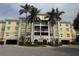 Elegant yellow condo building with lush landscaping and tall palm trees in a tropical setting at 255 West End Dr # 1302, Punta Gorda, FL 33950