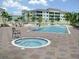 Community pool and spa with lush landscaping and lounge chairs on the patio at 255 West End Dr # 1302, Punta Gorda, FL 33950