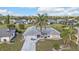 Aerial view of a single Gathering home with a palm tree in the front yard, manicured lawn, and neighborhood at 26166 Paysandu Dr, Punta Gorda, FL 33983