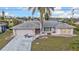 Exterior view of single Gathering home showing stone veneer accents, well maintained lawn, and two car garage at 26166 Paysandu Dr, Punta Gorda, FL 33983