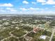 Aerial view of the home's location, nestled within a lush, tree-filled neighborhood and blue sky at 2621 San Maria Cir, North Port, FL 34286