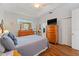 Inviting main bedroom with wood floors, a dresser, and a ceiling fan at 2621 San Maria Cir, North Port, FL 34286