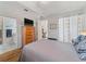 Well-lit main bedroom with wood floors, a dresser, and a view to the en-suite at 2621 San Maria Cir, North Port, FL 34286