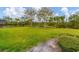 Large backyard features a lush lawn, landscaping, and a peaceful pond, creating a serene outdoor space at 2639 Hobblebrush Dr, North Port, FL 34289