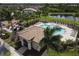 Aerial view of the community pool featuring a large pool, lounge chairs, and shade cabana at 2639 Hobblebrush Dr, North Port, FL 34289