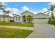 Charming single Gathering home with a two-car garage, arched entryway, and well-maintained front lawn at 2639 Hobblebrush Dr, North Port, FL 34289