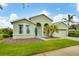 Home featuring a well-manicured lawn, arched entryway, and a two-car garage in a serene neighborhood at 2639 Hobblebrush Dr, North Port, FL 34289