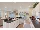 Open kitchen featuring sleek white cabinets, black countertops, stainless steel dishwasher, sink, and bar seating at 2639 Hobblebrush Dr, North Port, FL 34289