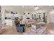 Open-concept living room with tile flooring, ceiling fan, and neutral decor adjacent to kitchen at 2639 Hobblebrush Dr, North Port, FL 34289