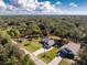 An aerial view of a house with a large yard, surrounded by lush greenery and a defined property line at 27385 Neaptide Dr, Punta Gorda, FL 33983