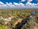 Aerial view shows waterfront home with canal frontage and surrounded by lush greenery at 27385 Neaptide Dr, Punta Gorda, FL 33983