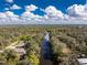 Expansive aerial view showcasing the property's waterfront location along a serene river surrounded by lush greenery at 27385 Neaptide Dr, Punta Gorda, FL 33983