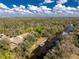 Aerial image highlighting the property's waterfront access, lush greenery, and a private dock on the tranquil river at 27385 Neaptide Dr, Punta Gorda, FL 33983