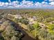 Aerial view shows waterfront home with private dock and surrounded by lush greenery at 27385 Neaptide Dr, Punta Gorda, FL 33983