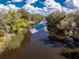 Picturesque view of the river with boat dock, serene waters reflecting the sky, and lush vegetation along the banks at 27385 Neaptide Dr, Punta Gorda, FL 33983