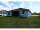 Exterior view of a house with a large, green backyard and screened-in porch at 342 Sweetwater Dr, Rotonda West, FL 33947