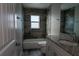 Beautiful bathroom with tiled walls, a tub, window, granite countertop and wood-look floor at 342 Sweetwater Dr, Rotonda West, FL 33947