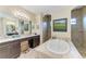 Bathroom features a soaking tub, walk-in shower, dual vanities, and a granite counter at 349 Springview Nw Cir, Port Charlotte, FL 33948