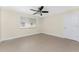 A tile floored bedroom with a ceiling fan, base trim, a window, and a door to the right at 35 Sabal Dr, Punta Gorda, FL 33950