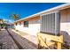 Beige house exterior with AC unit, stone walkway, and view of palm trees under a sunny blue sky at 35 Sabal Dr, Punta Gorda, FL 33950