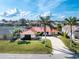 Inviting single-story home with a red roof, lush lawn and mature palms at 35 Sabal Dr, Punta Gorda, FL 33950